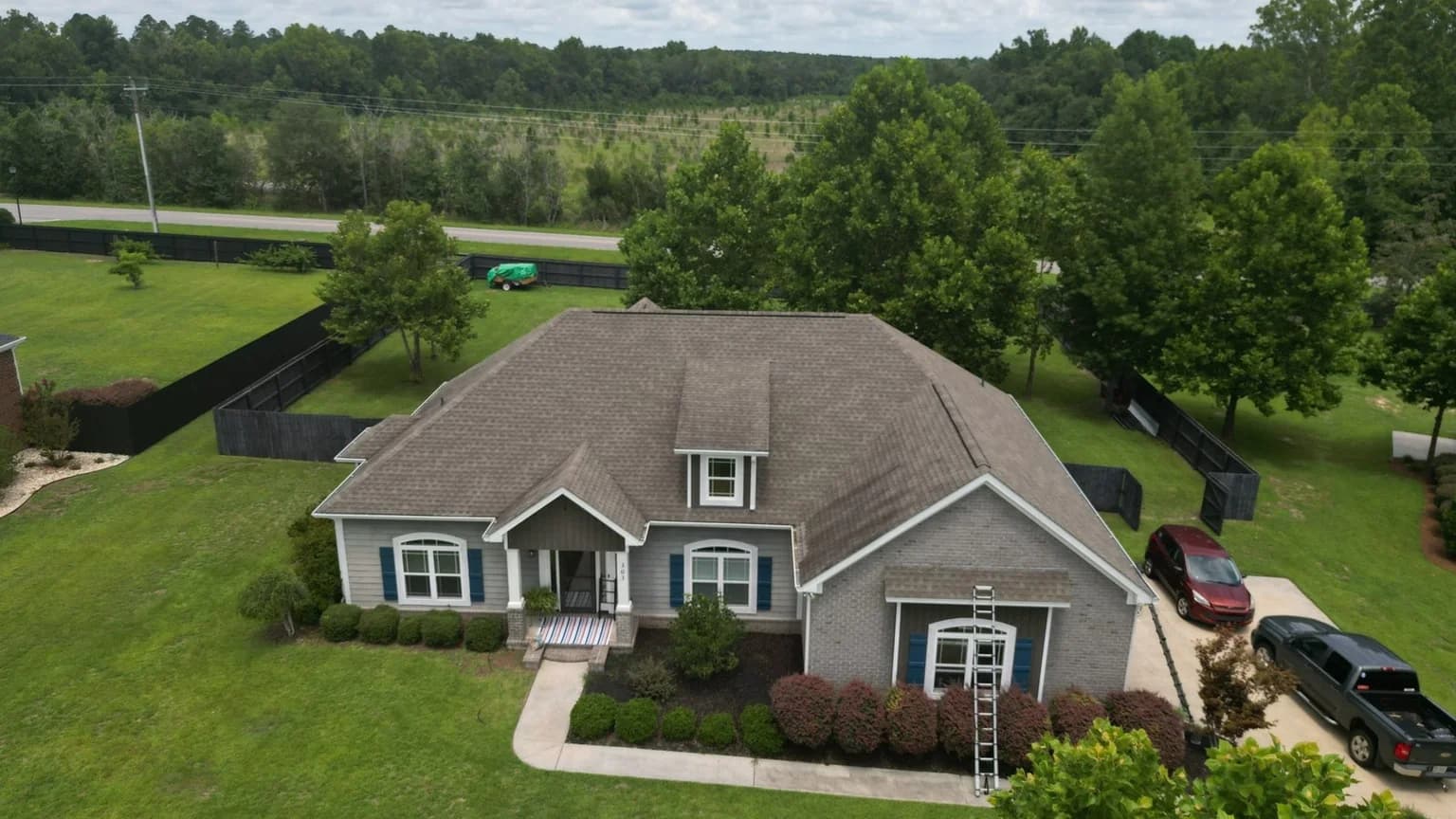 Completed asphalt shingle roof on a Statesboro GA home framed by tall Bulloch County pines