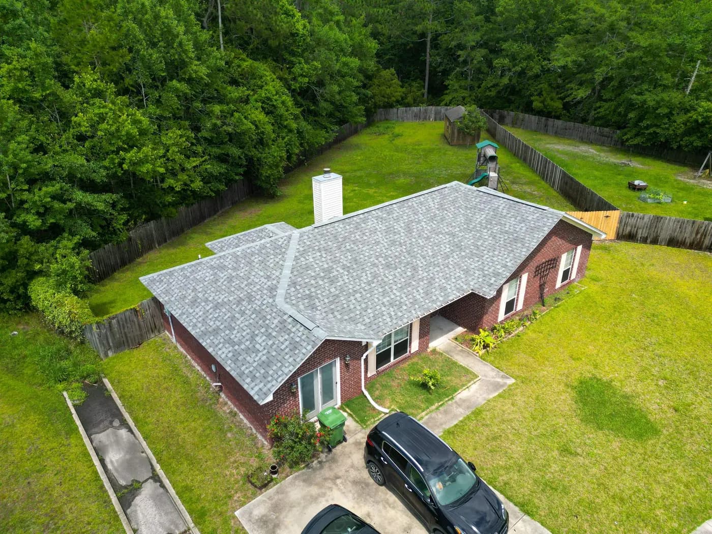 Top-down aerial view of a completed gray architectural shingle roof in Hinesville, Georgia.