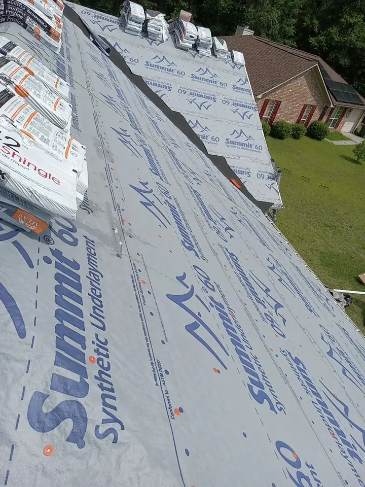 Synthetic roofing underlayment installed during the dry-in stage of a roof replacement.