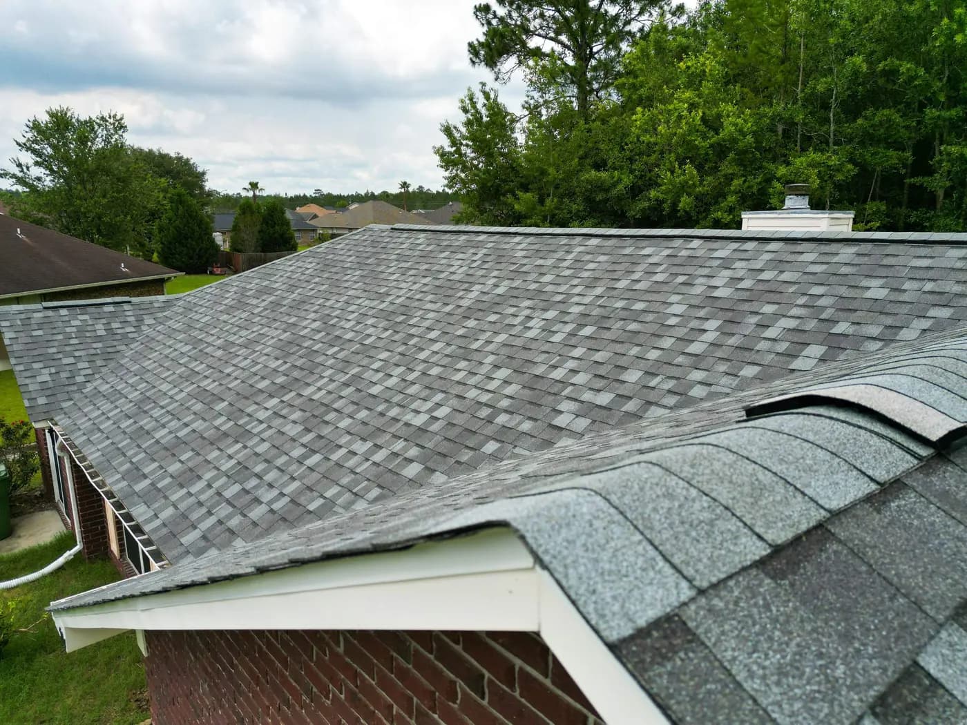 Completed Atlas architectural shingles across the main roof planes, hips, and ridges.